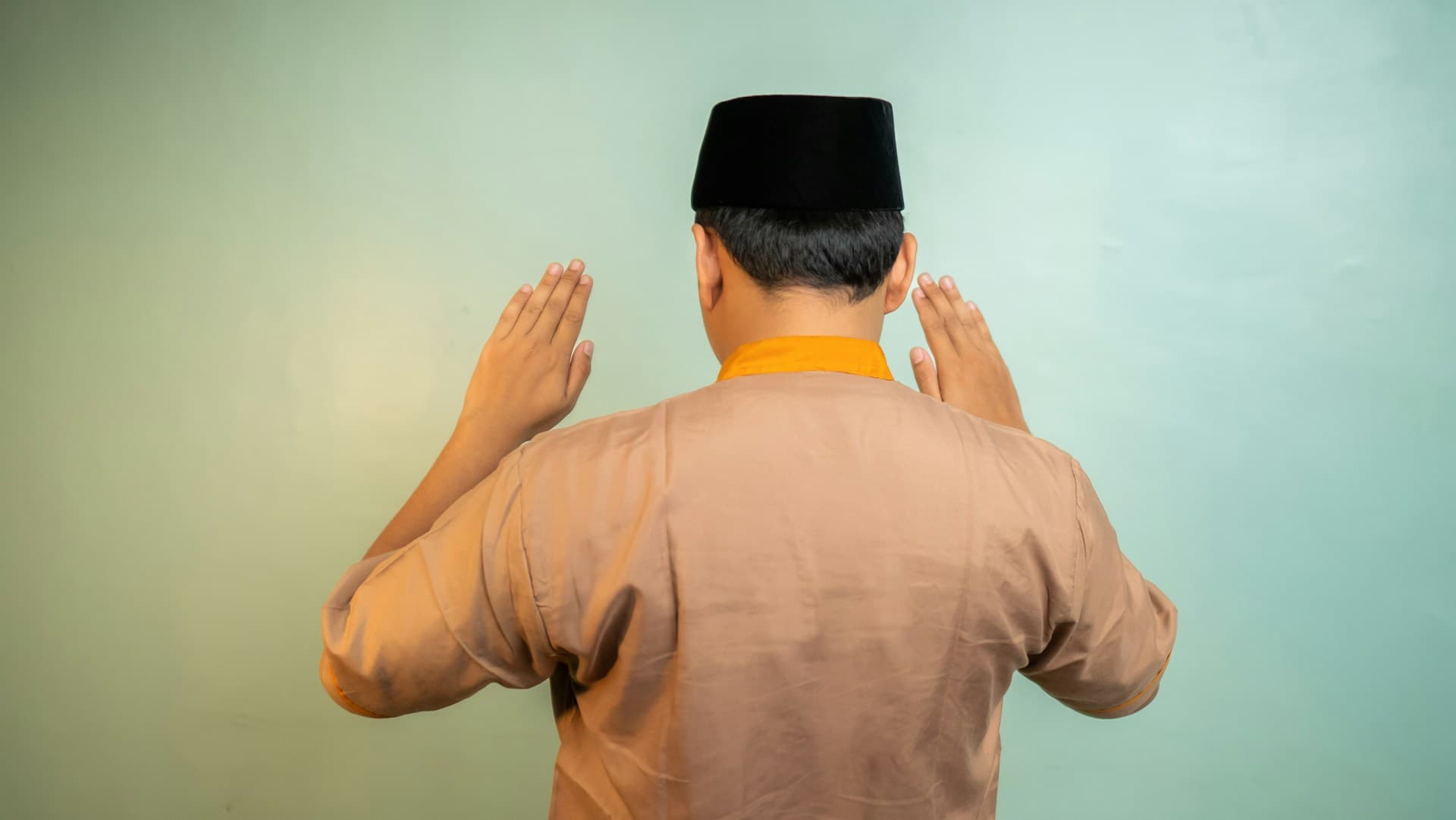 Seorang muslim mengangkat kedua tangan saat takbiratul ihram
