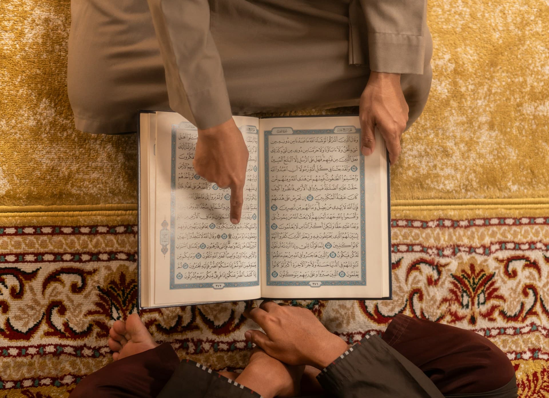 Seorang pengajar menunjuk ayat Al-Quran saat membimbing muridnya