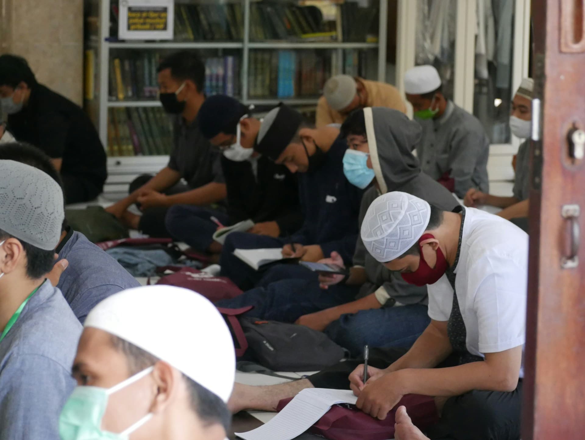 Jamaah duduk mencatat materi selama kajian berlangsung